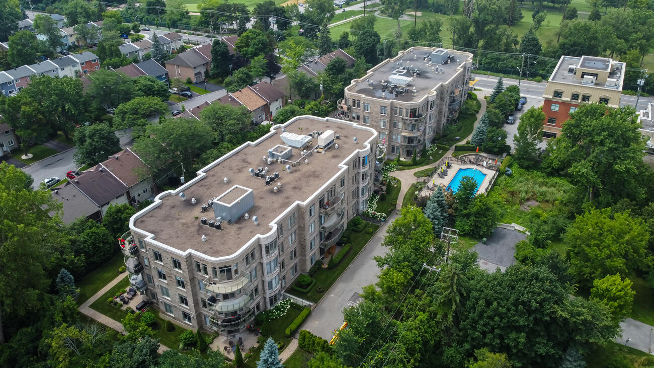 Aerial view of the two buildings of Le Cartier du Village surrounded by trees